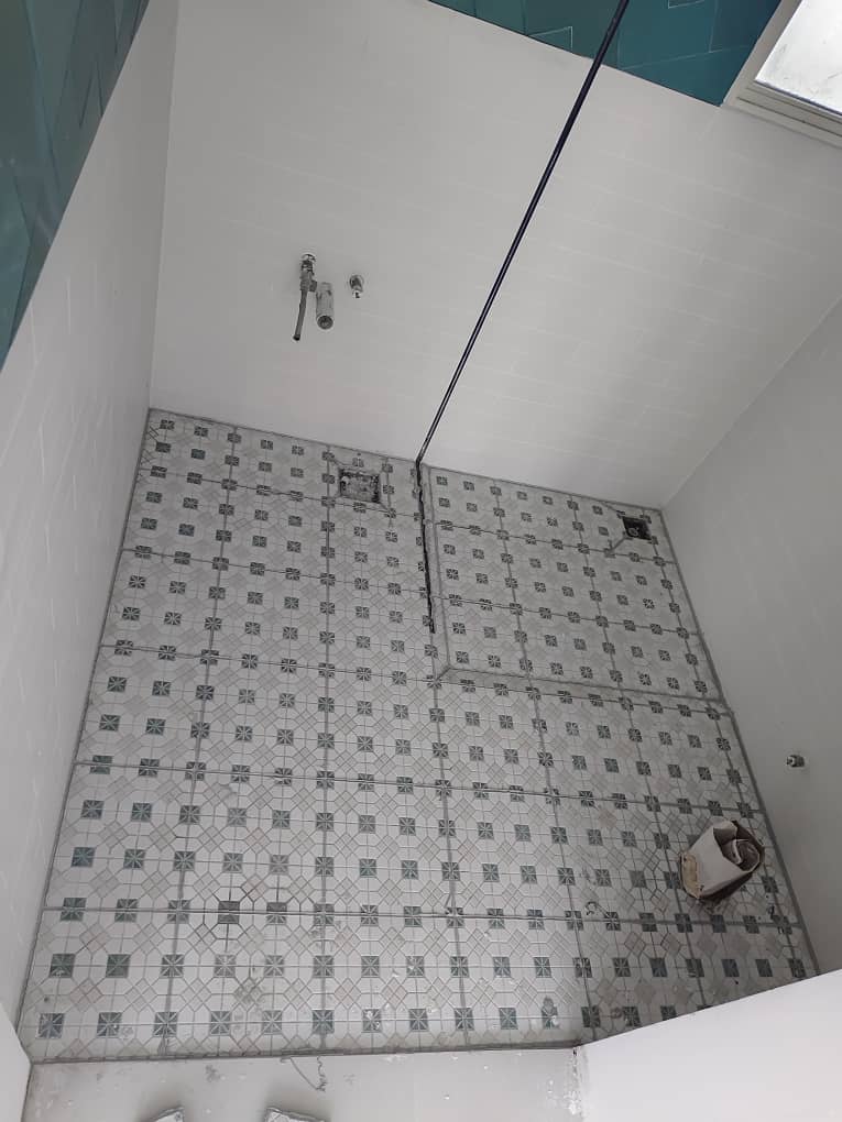Bathroom floor tiles before epoxy grouting, with worn grout lines